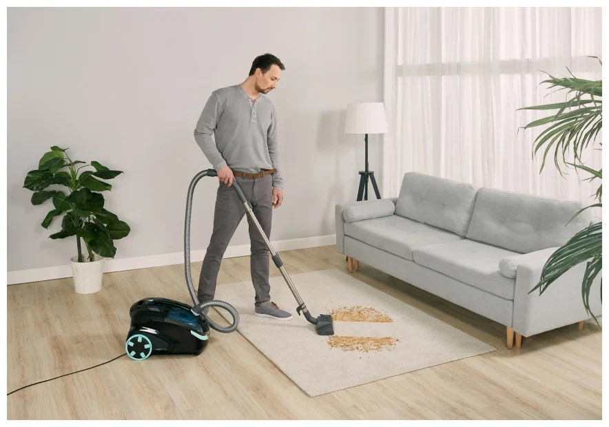 A man is cleaning the carpet with cleaner